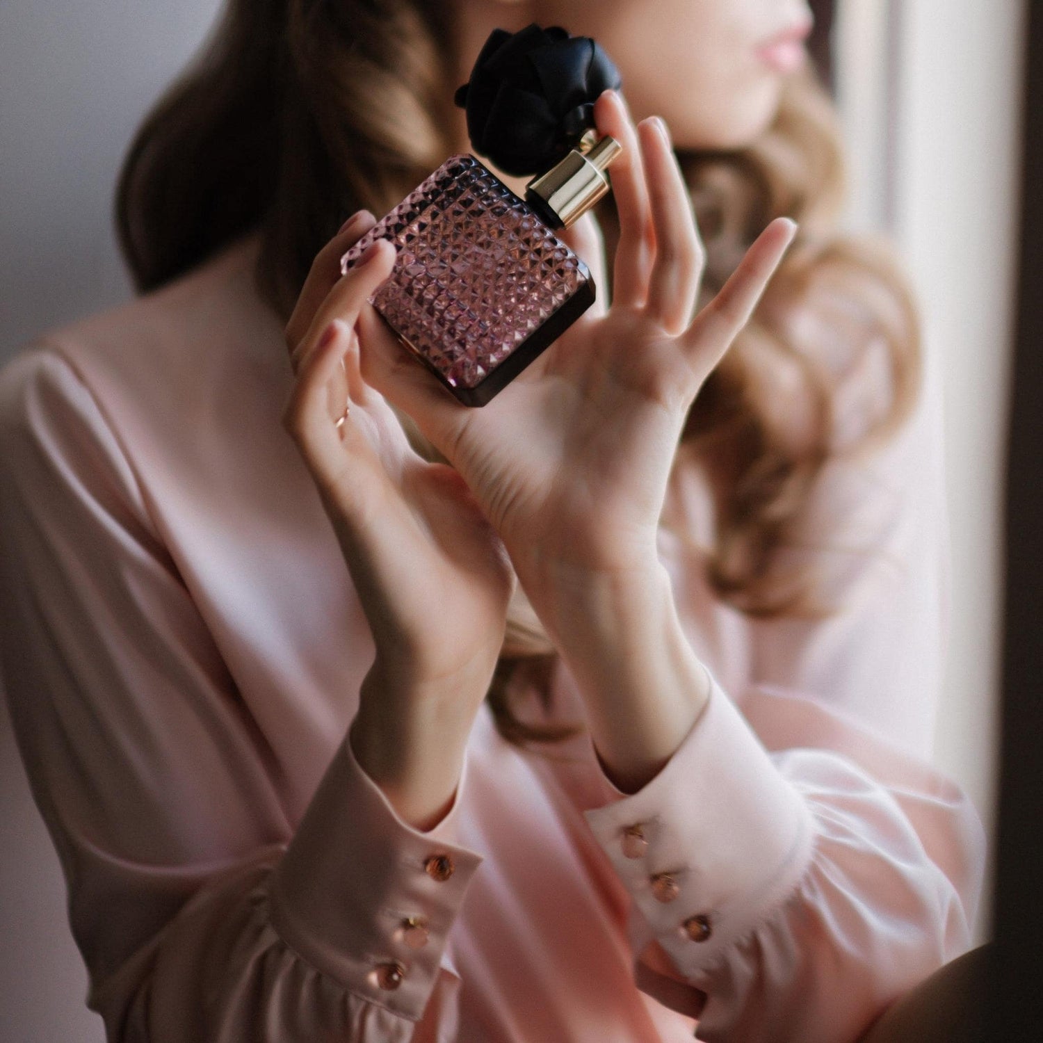 Woman in Pink Applying Perfume